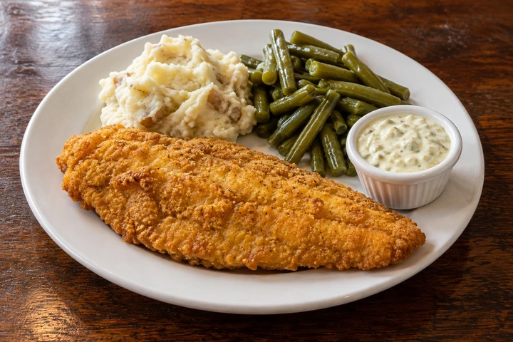 Illustrative one-fillet fish dinner with mashed potatoes and green beans.